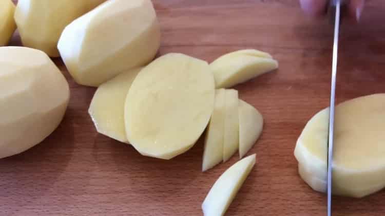 За да готвите пилешки гърди с картофи във фурната, нарежете картофите
