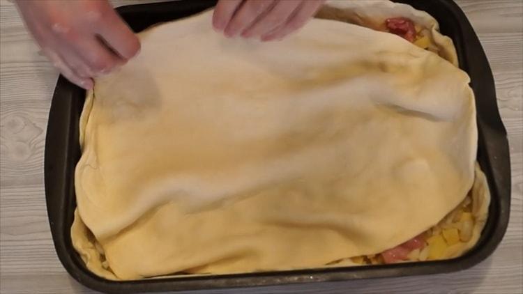 Decken Sie die Füllung gemäß dem Rezept zum Garen von Hühnchen mit Kartoffeln mit Teig ab