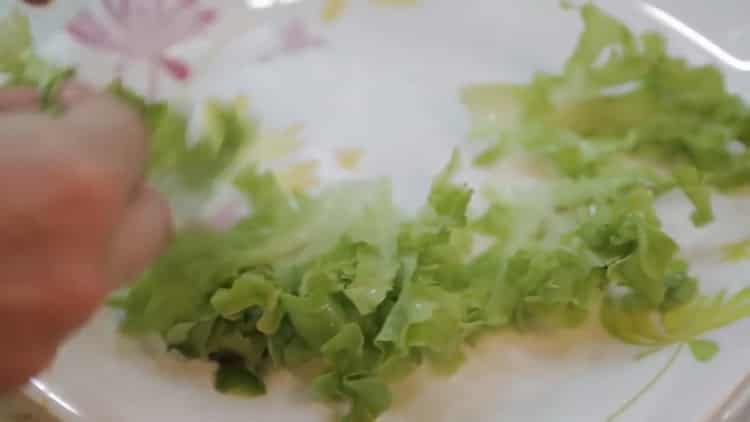 A lazac sütőben, fóliában történő elkészítéséhez vágjon salátát