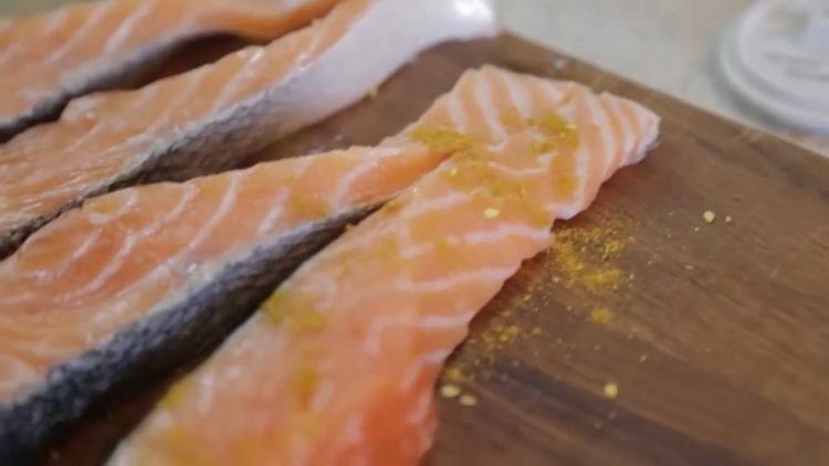 Per cucinare il salmone al forno in un foglio, salare e pepare il pesce