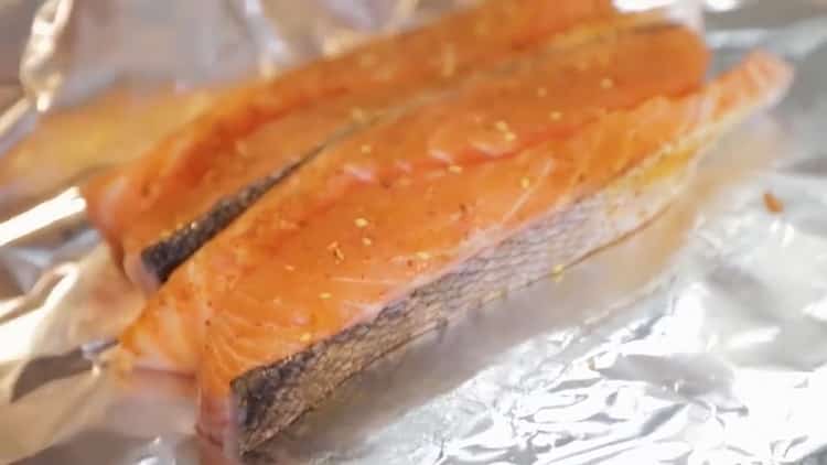 Um Lachs im Ofen in einer Folie zuzubereiten, legen Sie den Fisch in eine Folie