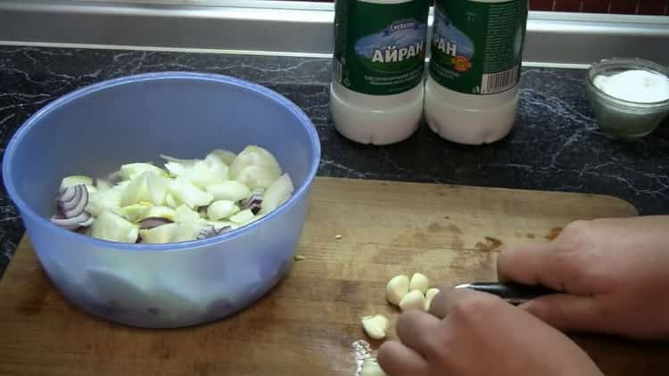 Per cucinare la marinata di coniglio nel forno, tagliare l'aglio