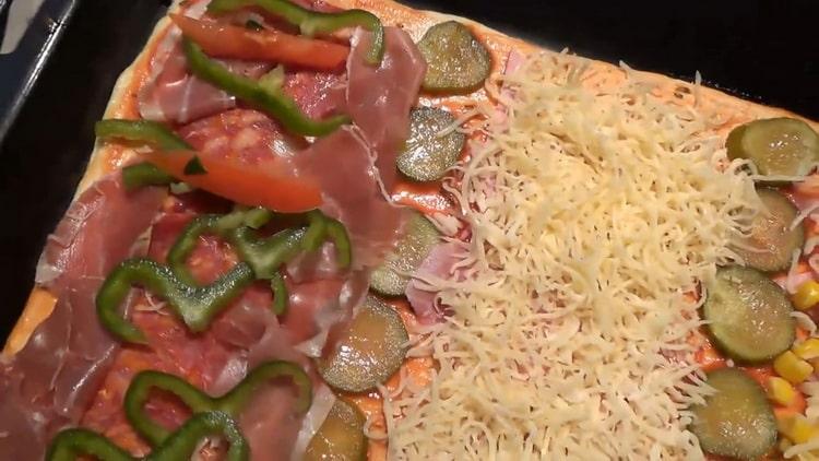 Pane pizza tomaatit makkaran päälle, jotta pizza täytettäisiin