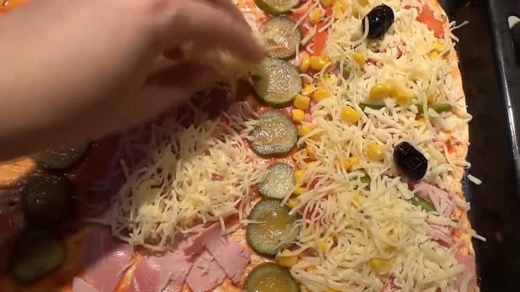 A pizza öntetek készítéséhez fektesse le az összetevőket a pizzára