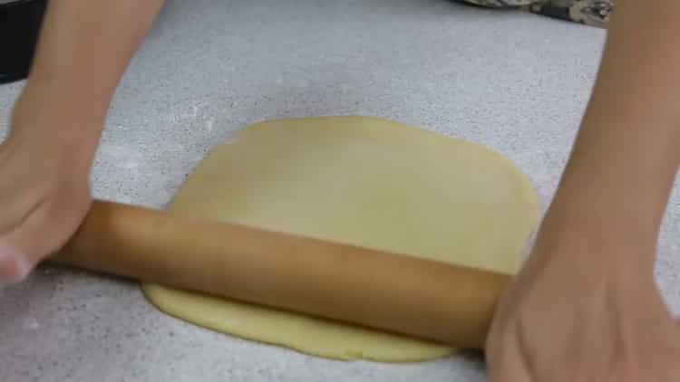 Den Teig ausrollen, um einen offenen Kuchen mit Hüttenkäse zuzubereiten