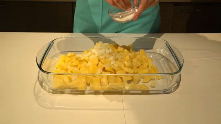 Für die Zubereitung von Heilbutt die Zwiebeln und Kartoffeln in eine Form geben