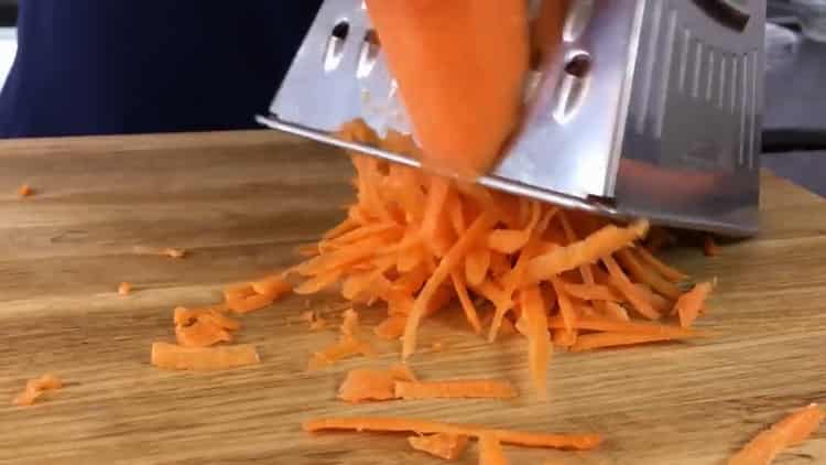 Reiben Sie die Karotten, um einen Rinderleberkuchen nach einem einfachen Rezept zuzubereiten