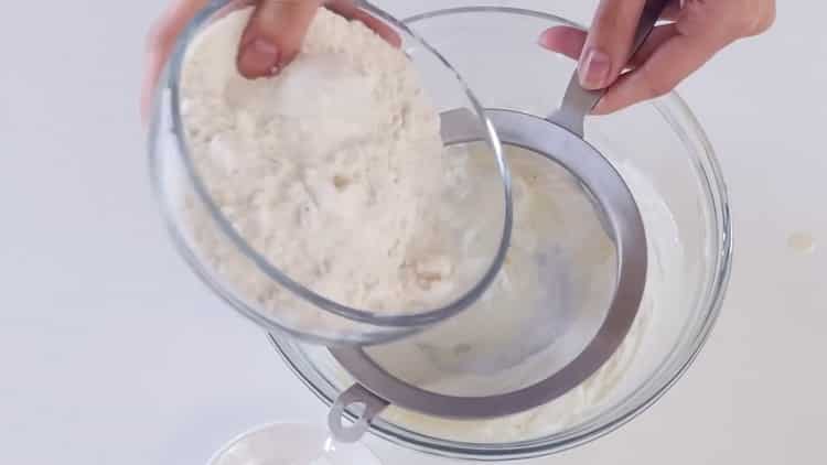Mehl sieben, um Kekse mit Füllung zu machen