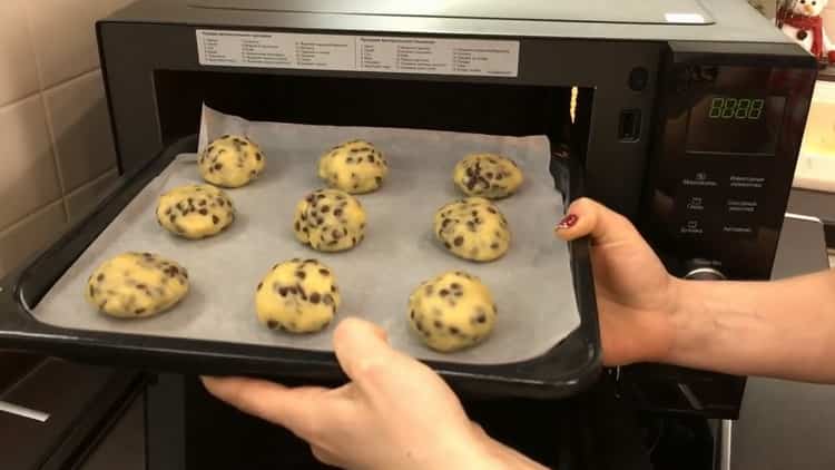 Um Kekse mit Schokoladenstückchen zu backen, legen Sie das Backblech in den Ofen