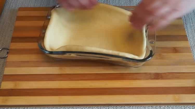 A sütővel gombával készített pite elkészítéséhez tegye a tésztát az alakba