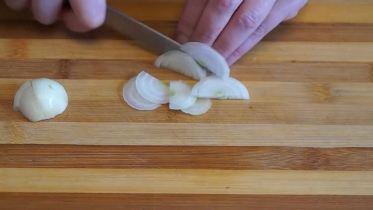 Για να φτιάξετε ένα μανιτάκι στο φούρνο, κόψτε το κρεμμύδι για το γέμισμα