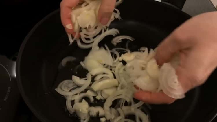 لعمل فطيرة مع الكرنب والبيض في الفرن ، قم بقطع البصل