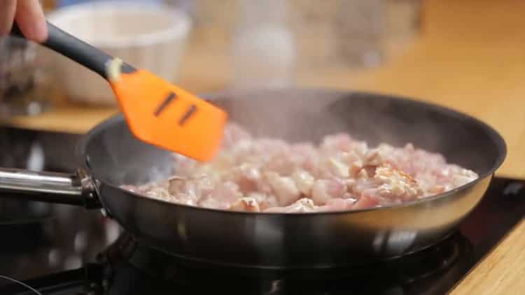 Braten Sie das Fleisch an, um Hähnchen-Pilz-Kuchen zuzubereiten