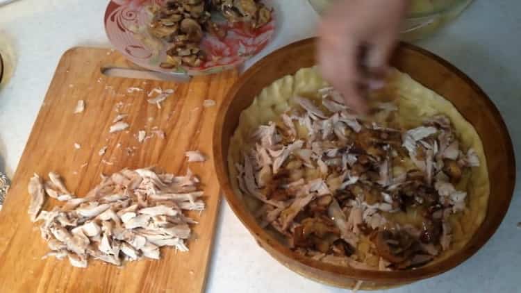 Per preparare la torta di pollo, mettere il ripieno sull'impasto