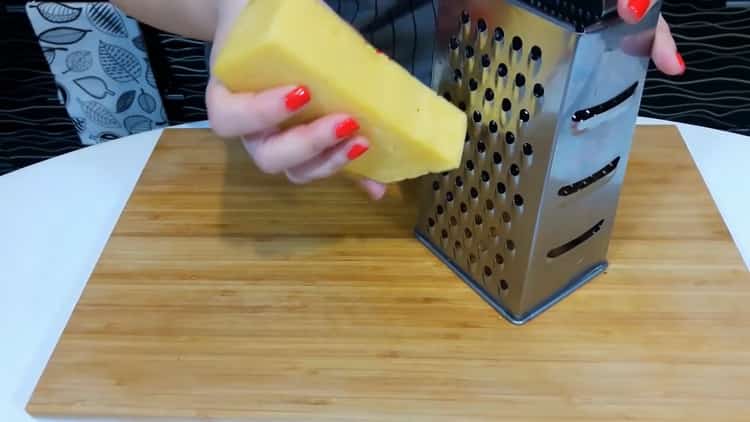 Per fare la pizza a casa, grattugiare il formaggio