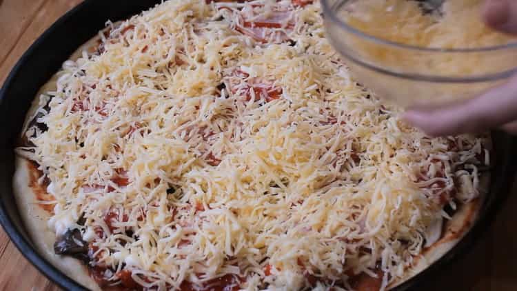 Um Pizza im Ofen zuzubereiten, geben Sie den Käse auf die Füllung