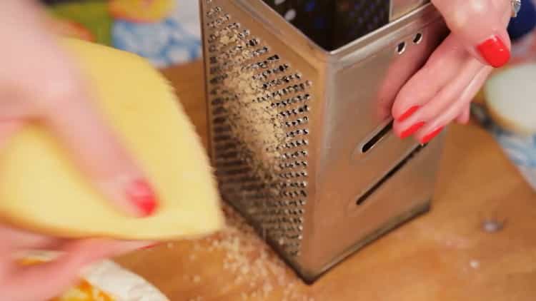 Per fare la pizza al microonde, grattugiare il formaggio