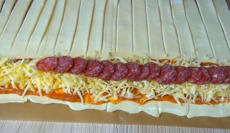 За да направите пица с бутер тесто, сложете соса и пълнежа върху тестото