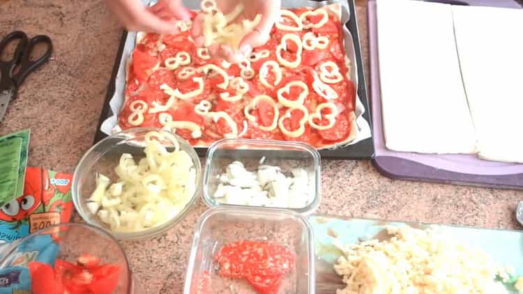 Pentru a face pizza de patiserie puf la cuptor, introduceți ingredientele pe aluat