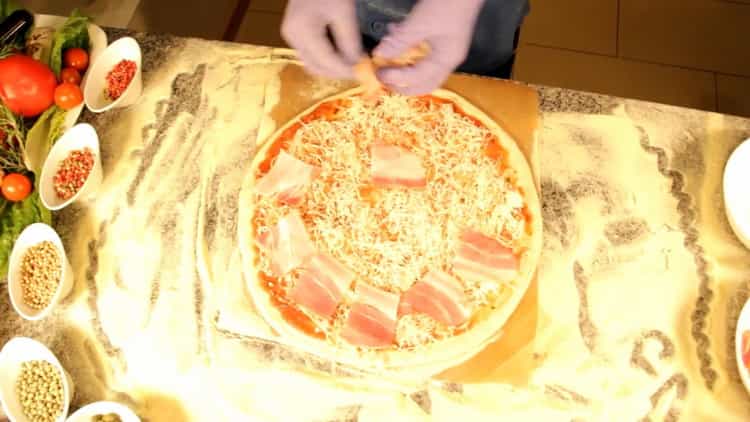 لصنع بيتزا كاربونارا ، ضعي لحم الخنزير المقدد على العجينة