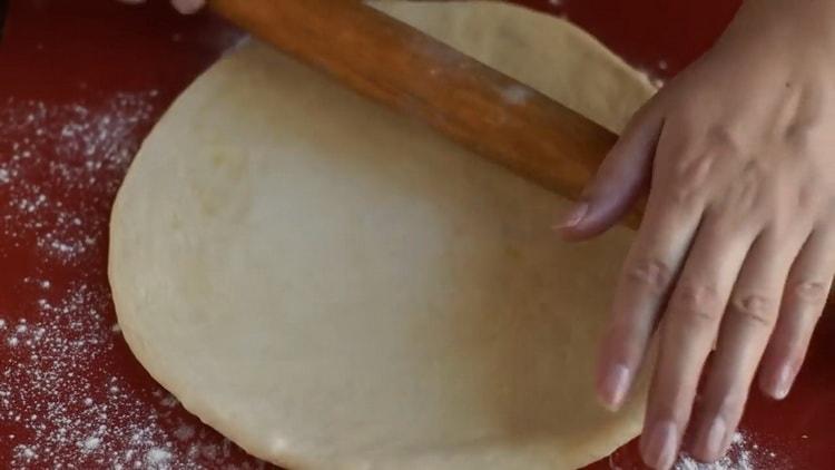 Разточете тестото, за да направите пица с маргарита