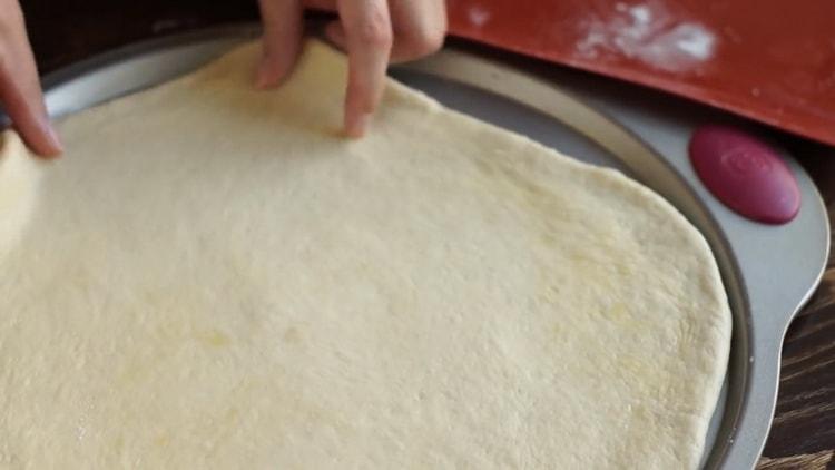 لصنع بيتزا مارغريتا ، ضعي العجينة على القالب