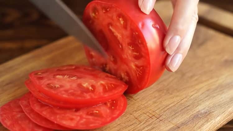 Für die Zubereitung von Margarita-Pizza die Tomate hacken