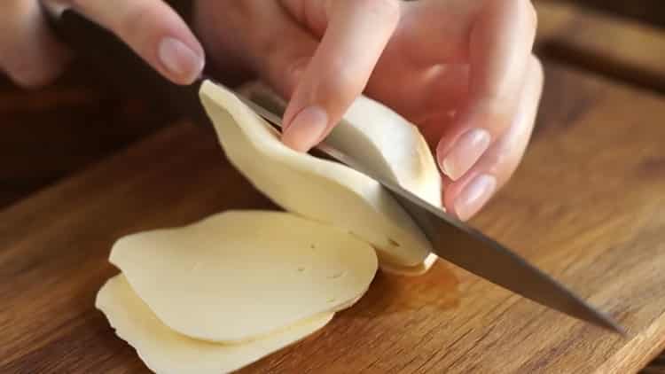 Per preparare la pizza alla margarita, tagliare il formaggio