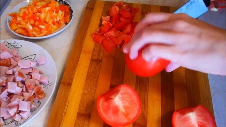 Zum Pizza backen Tomaten in Scheiben schneiden