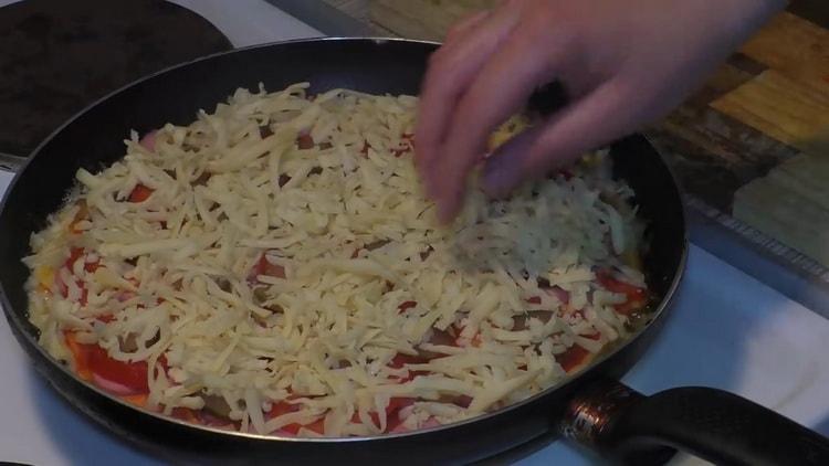 Reiben Sie Käse, um Pizza in einer Pfanne zuzubereiten