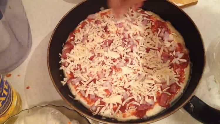 Käse reiben, um Pizza zu machen