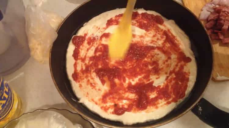 За да направите пица, намажете тестото с доматено пюре