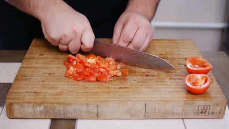 Pizzapiirakan valmistamiseksi pilkkoa tomaatit