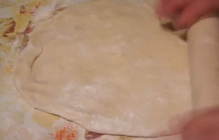 Kolbászos és sajtos pizza készítéséhez gördítse le a tésztát
