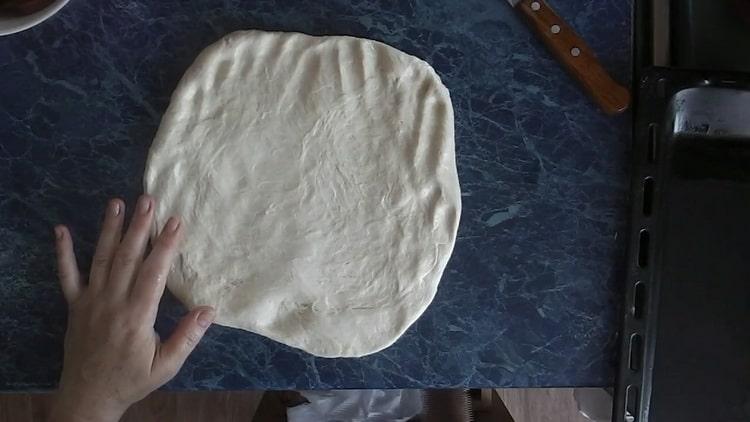 Разточете тестото, за да направите пица с туршии