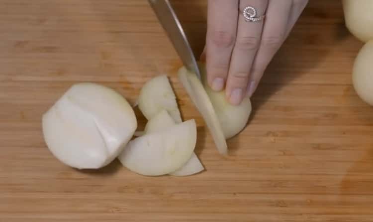Zwiebel hacken, um Lammpilaf in einem Kessel zu kochen
