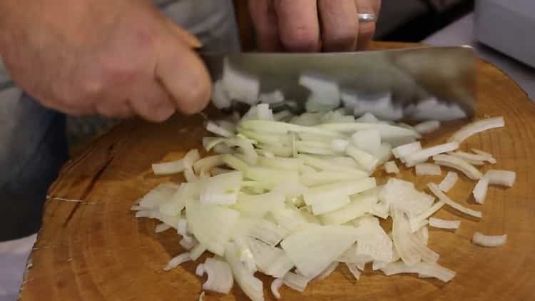 لطهي لحم الخنزير بيلاف في مقلاة ، يقطع البصل