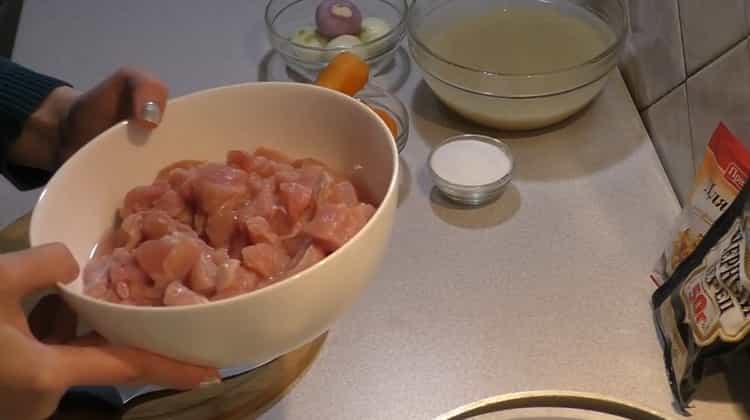 Zum Kochen von Pilaw mit Huhn in einem Kessel das Fleisch hacken