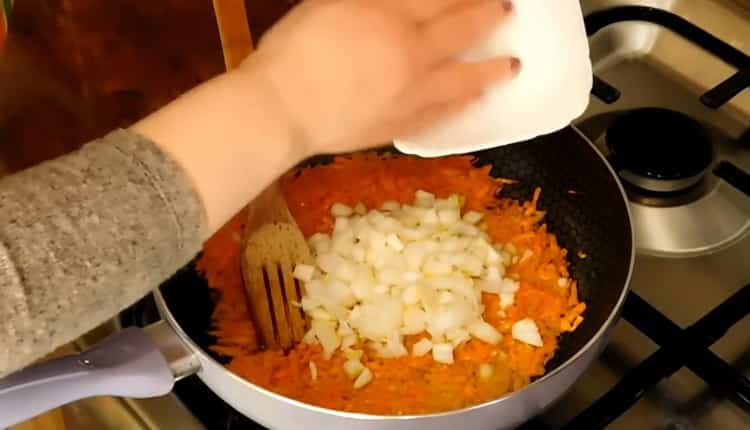 Friggi cipolle e carote per preparare una zuppa di pollo magra.