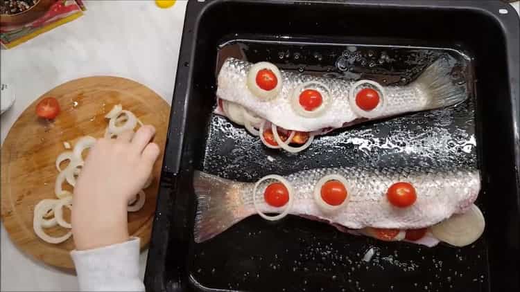 Um ein Lager im Ofen zu kochen, legen Sie die Tomaten auf den Fisch