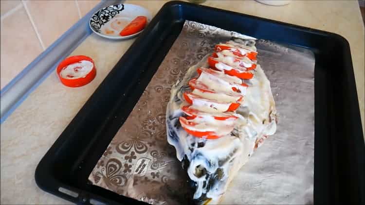 Um Kappa im Ofen zuzubereiten, legen Sie Tomaten auf den Fisch