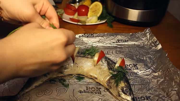 Um Fisch in einem langsamen Kocher zu kochen, legen Sie die Tomaten auf eine Folie