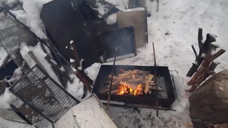 Norėdami gaminti karštai rūkytą žuvį, uždekite ugnį