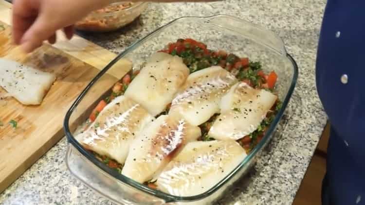 Per cucinare il pesce in greco, metti il ​​pesce sui pomodori