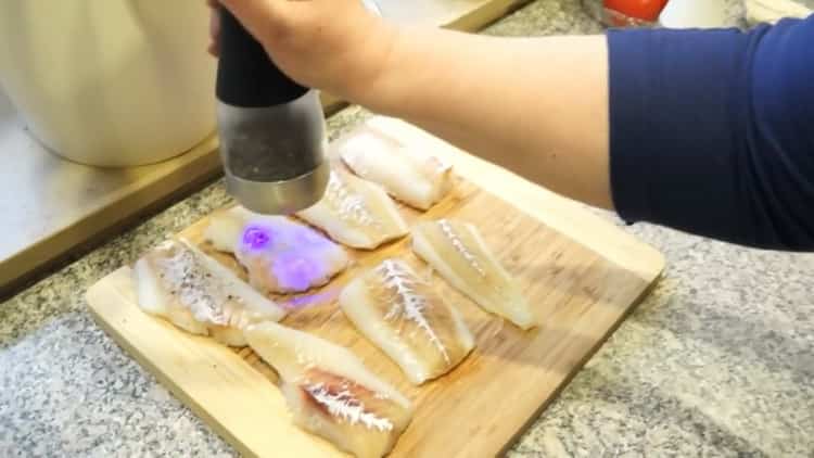 Um Fisch auf Griechisch zu kochen, salzen Sie den Fisch