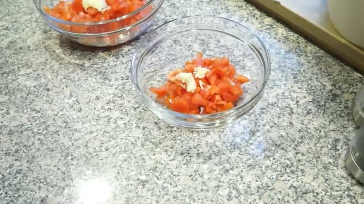 Per cucinare il pesce in greco, preparare una miscela di pomodori e aglio
