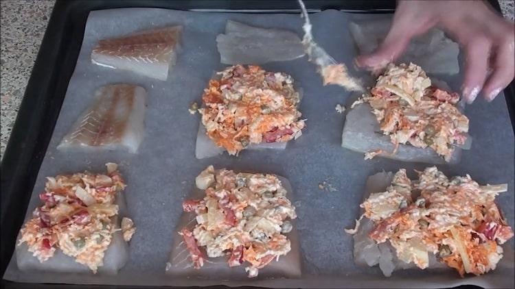 Um Fisch unter einem Pelzmantel im Ofen zu kochen, geben Sie die Füllung auf den Fisch