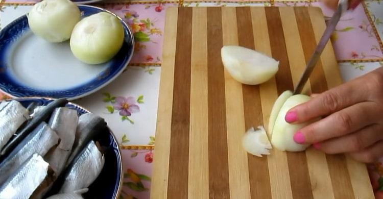 Για να κάνετε τη ρέγγα σύμφωνα με μια απλή συνταγή, κόψτε το κρεμμύδι