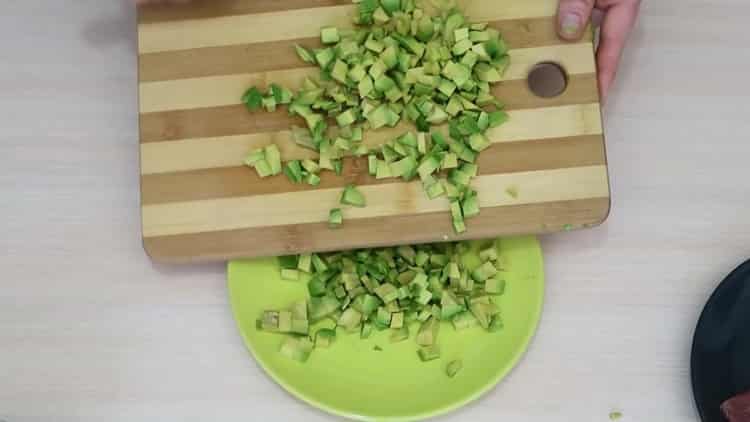 За да направите салата с авокадо и сьомга, нарежете авокадото