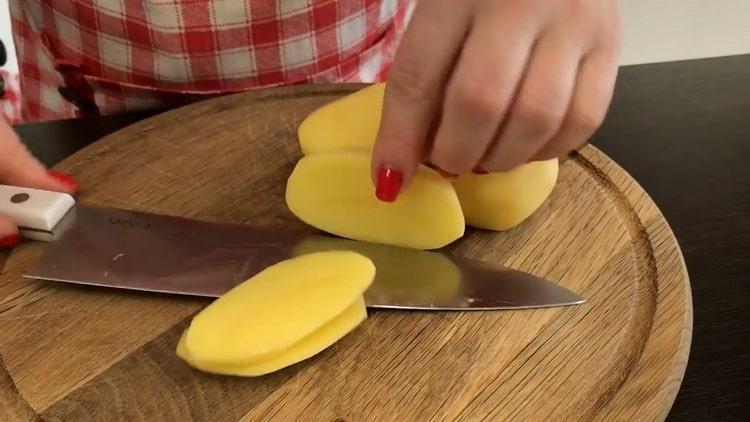 Για να μαγειρέψετε σκουμπρί σε αλουμινόχαρτο, ψιλοκόψτε τις πατάτες